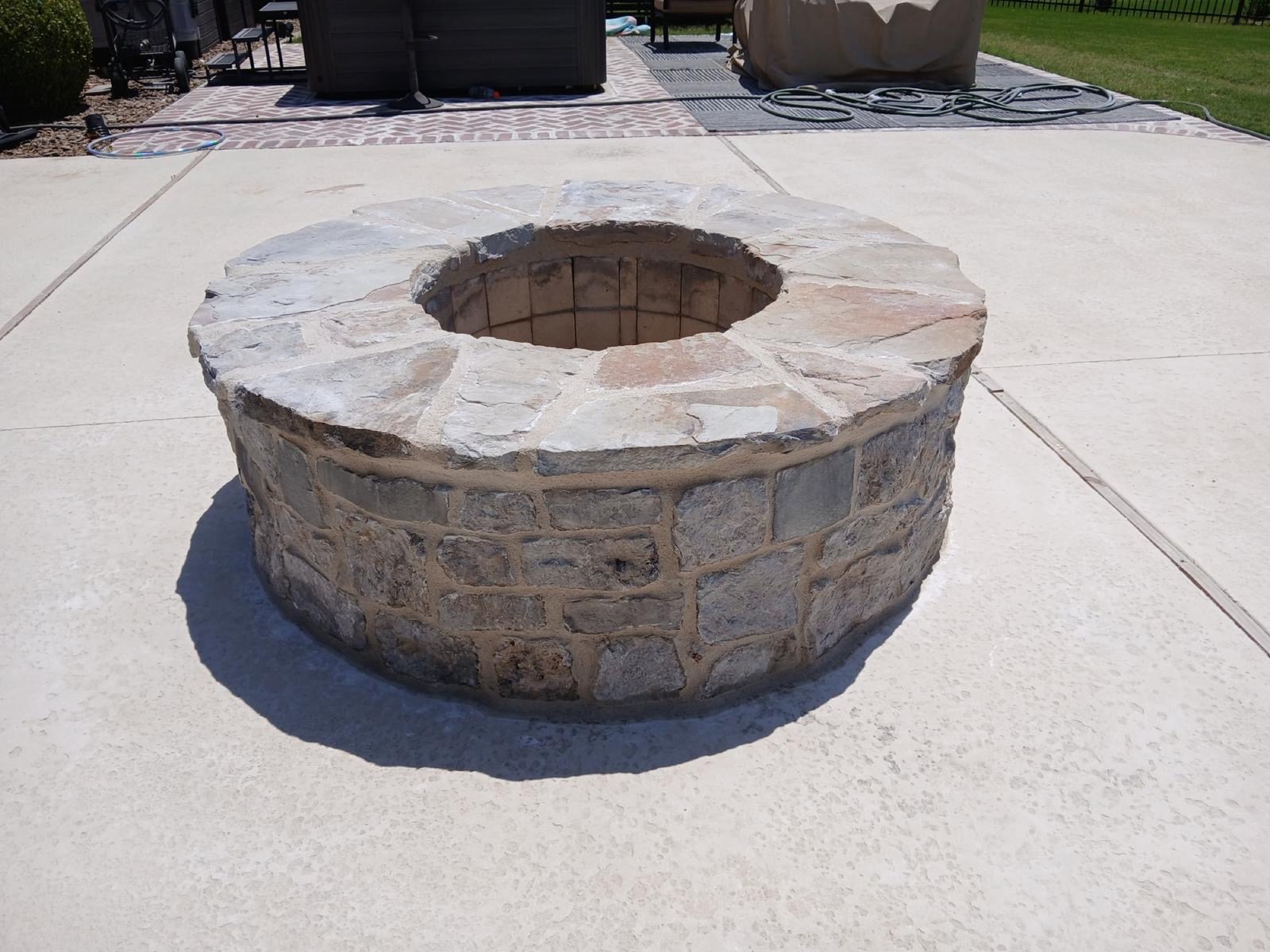 Finished stone veneer fire pit on a patio