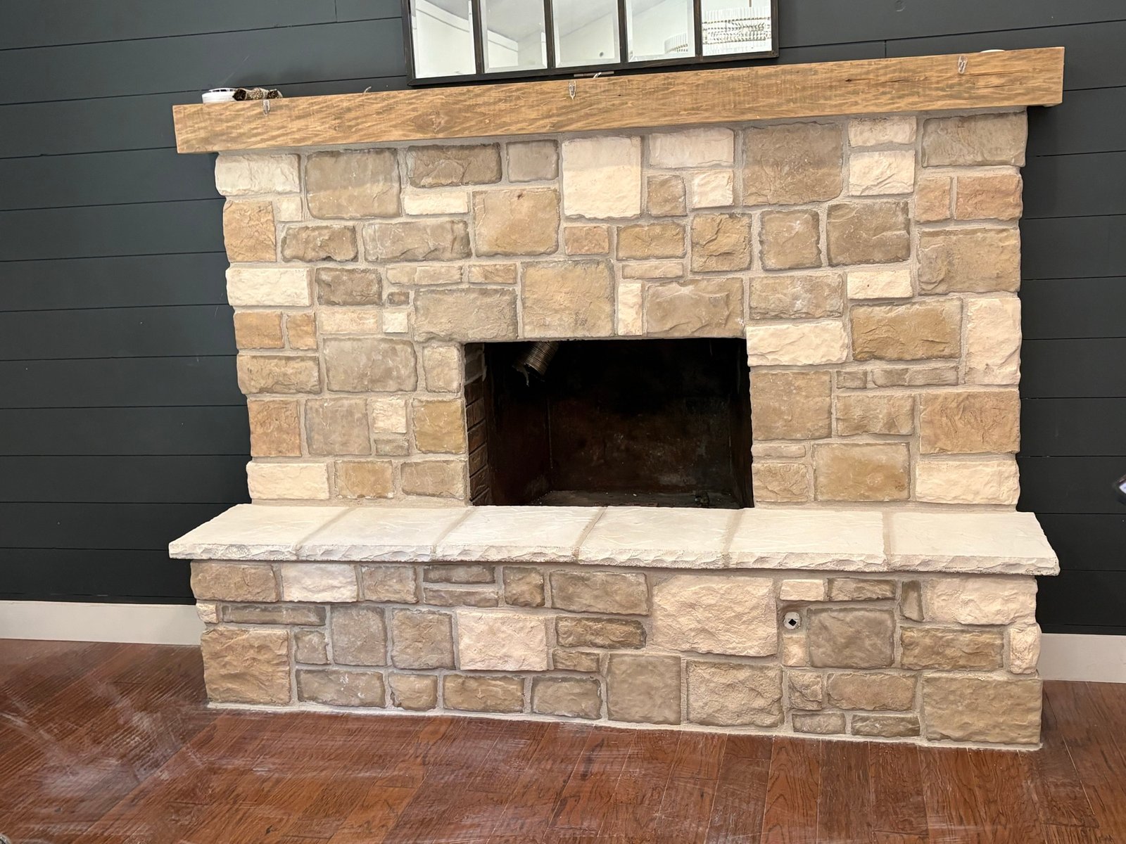 Interior stacked stone fireplace with wood mantel