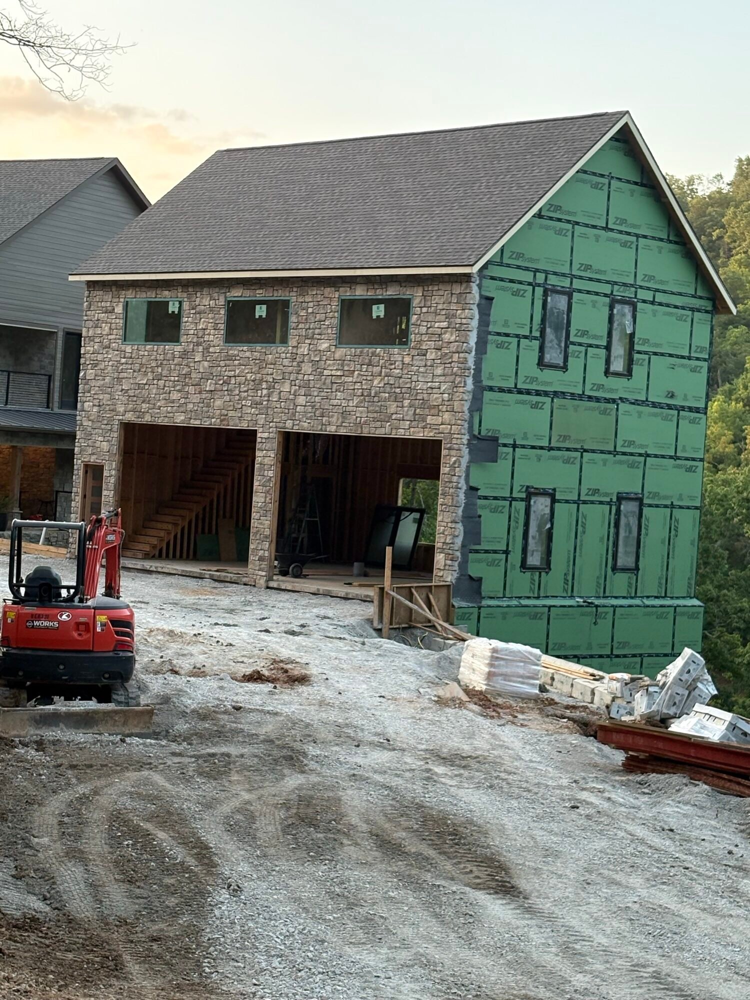 Stone veneer installation in progress, two-story wall